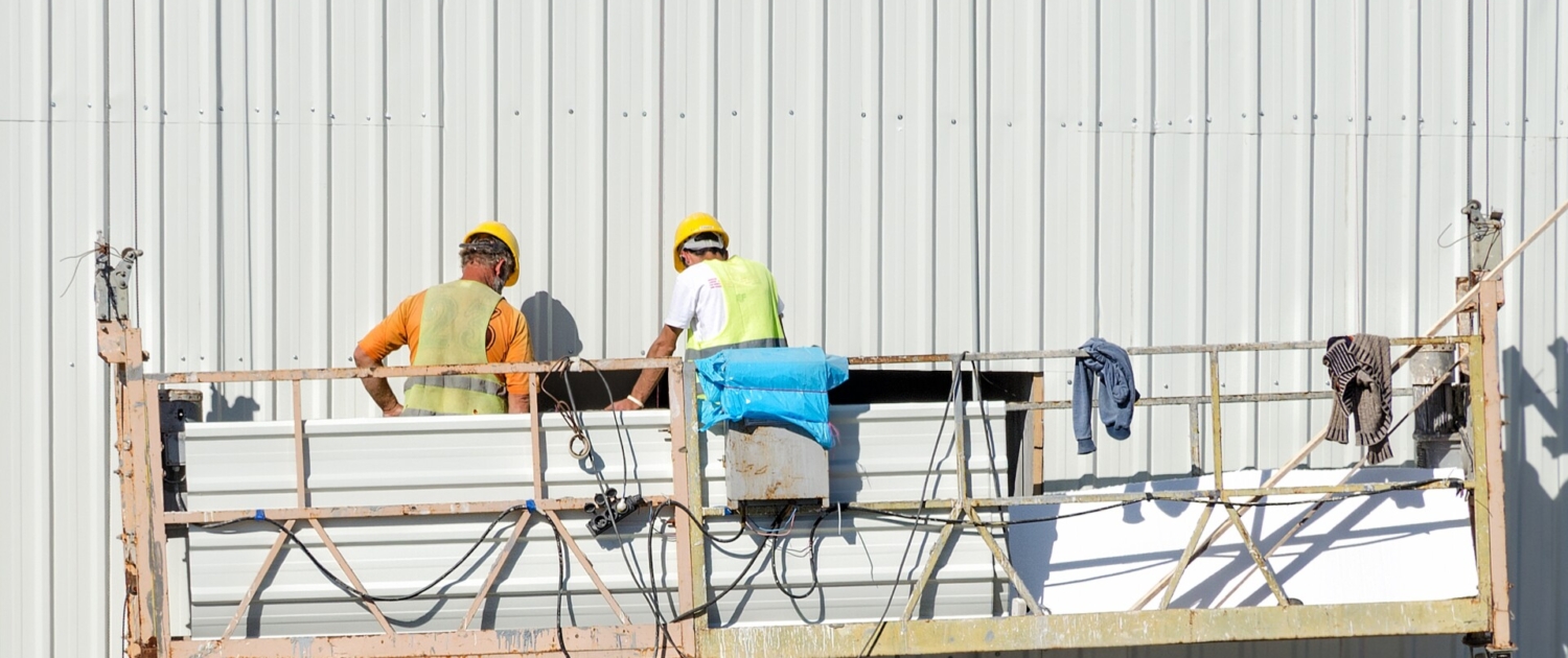 building cradle lifts workers on the wall of the house.